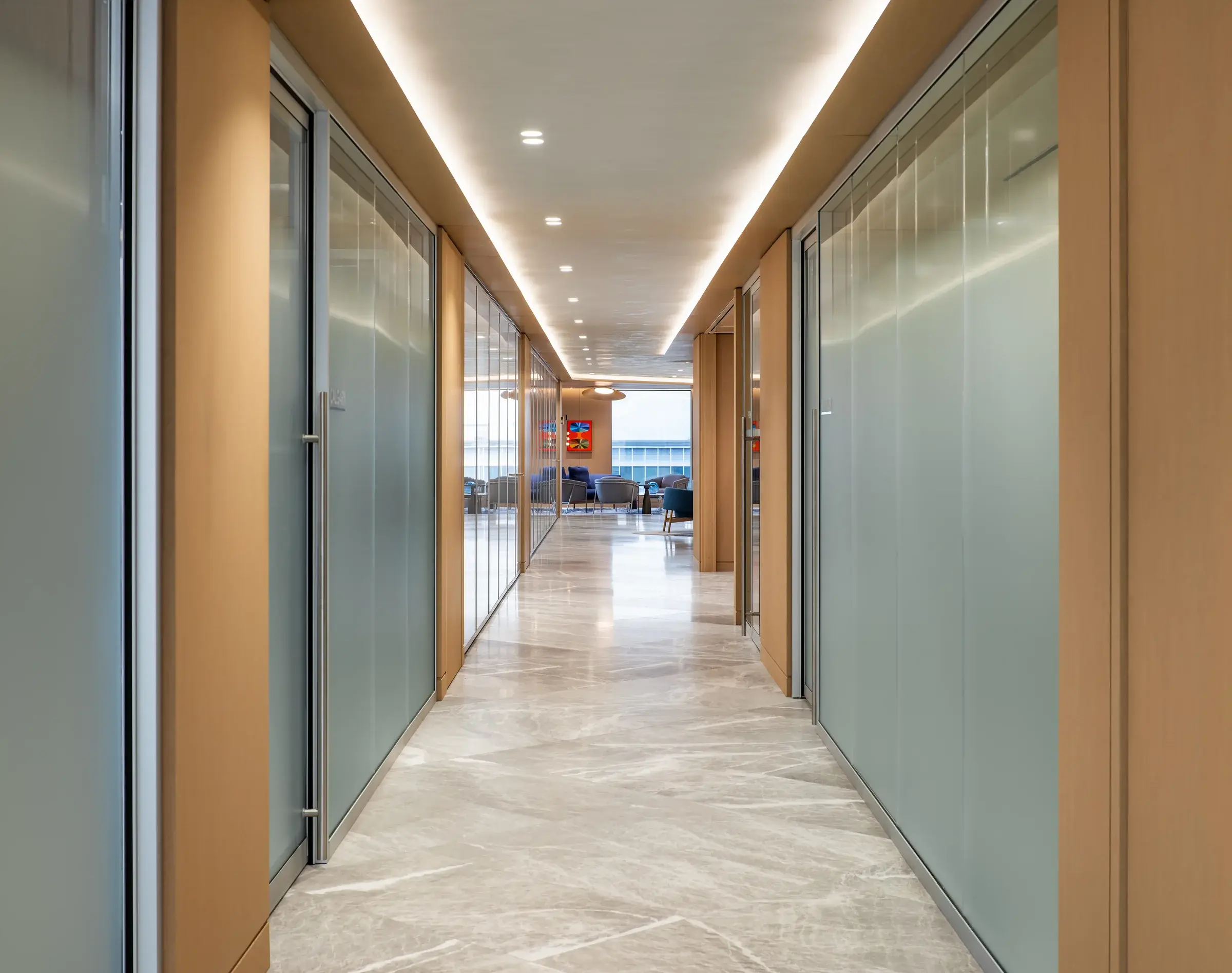 Corridor lined with architectural wall systems and glazed rooms