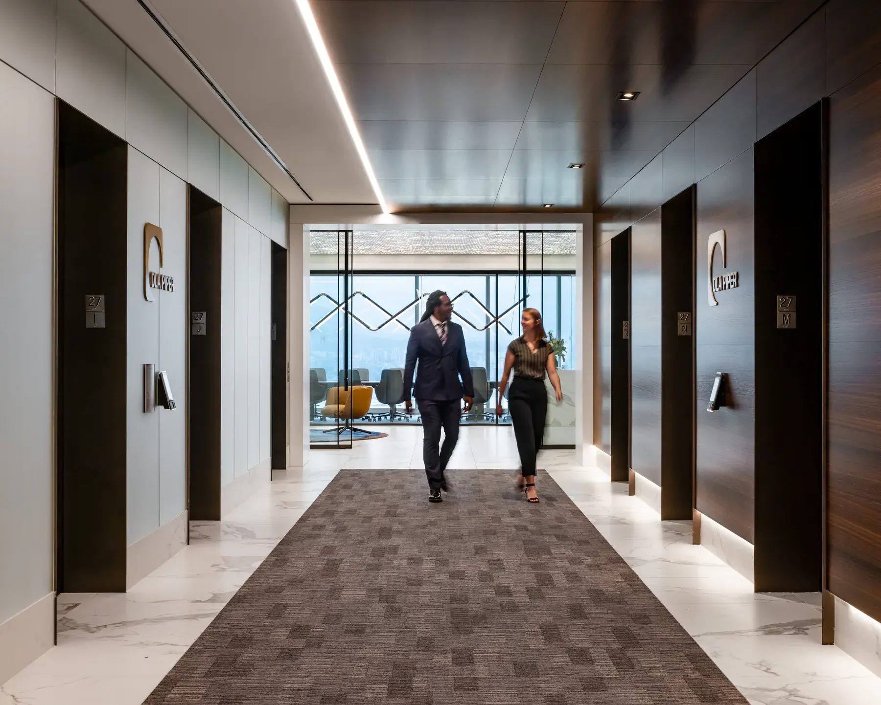 Two people walking through the DLA Piper Vancouver arrival corridor