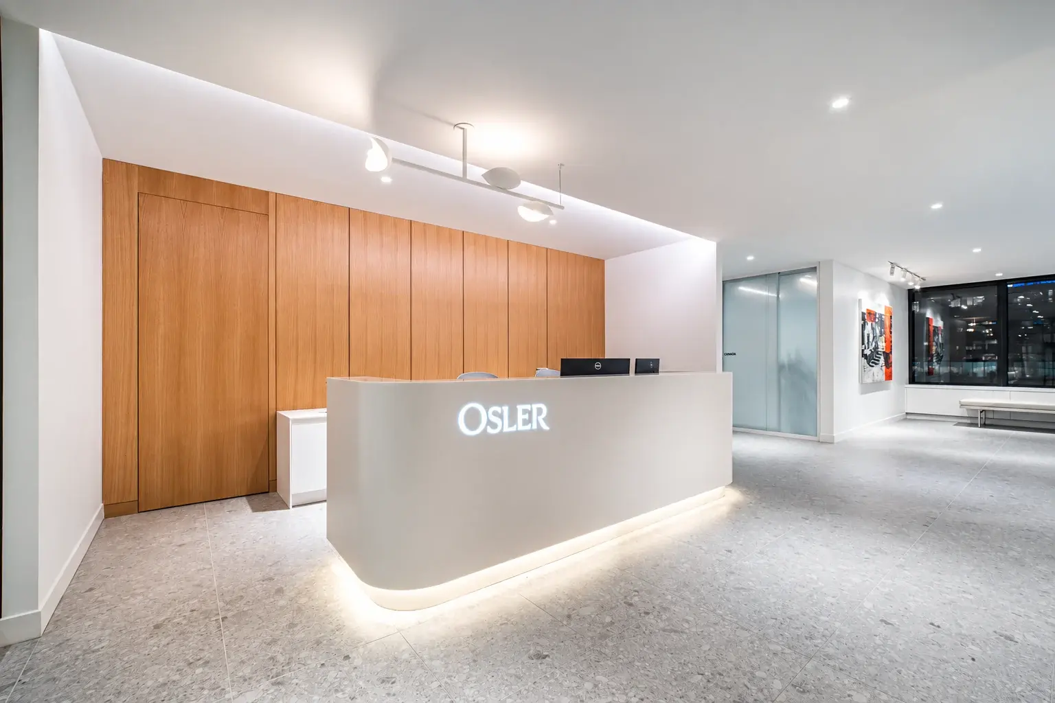 Osler reception desk and illuminated logo at the Vancouver workplace