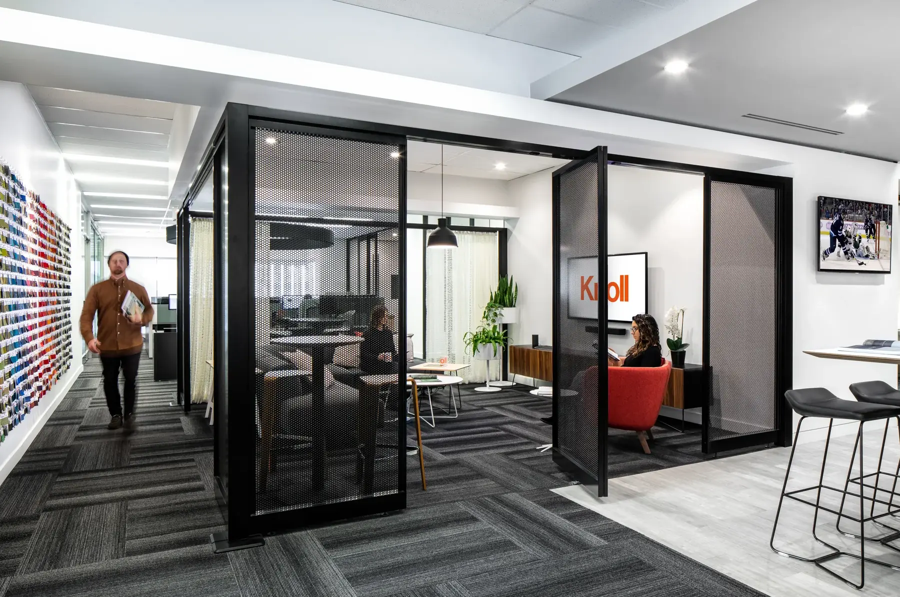 A person moving past an open meeting room in Blackburn Young's Vancouver workplace
