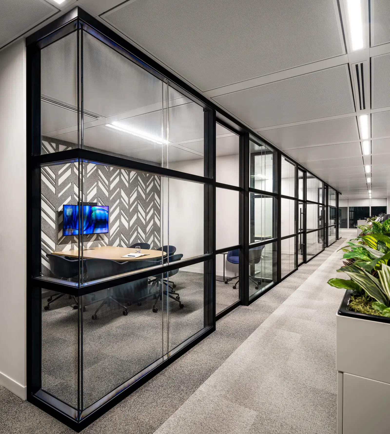 Glazed rooms lining a planted corridor in the Waypoint Insurance workplace