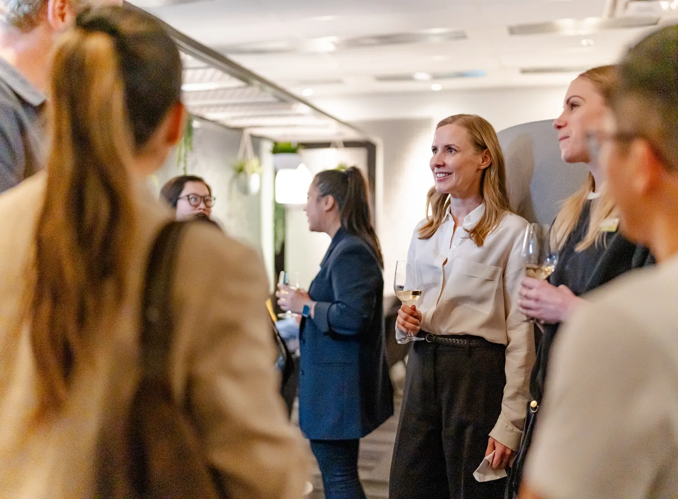 A group of guests in conversation inside the showroom