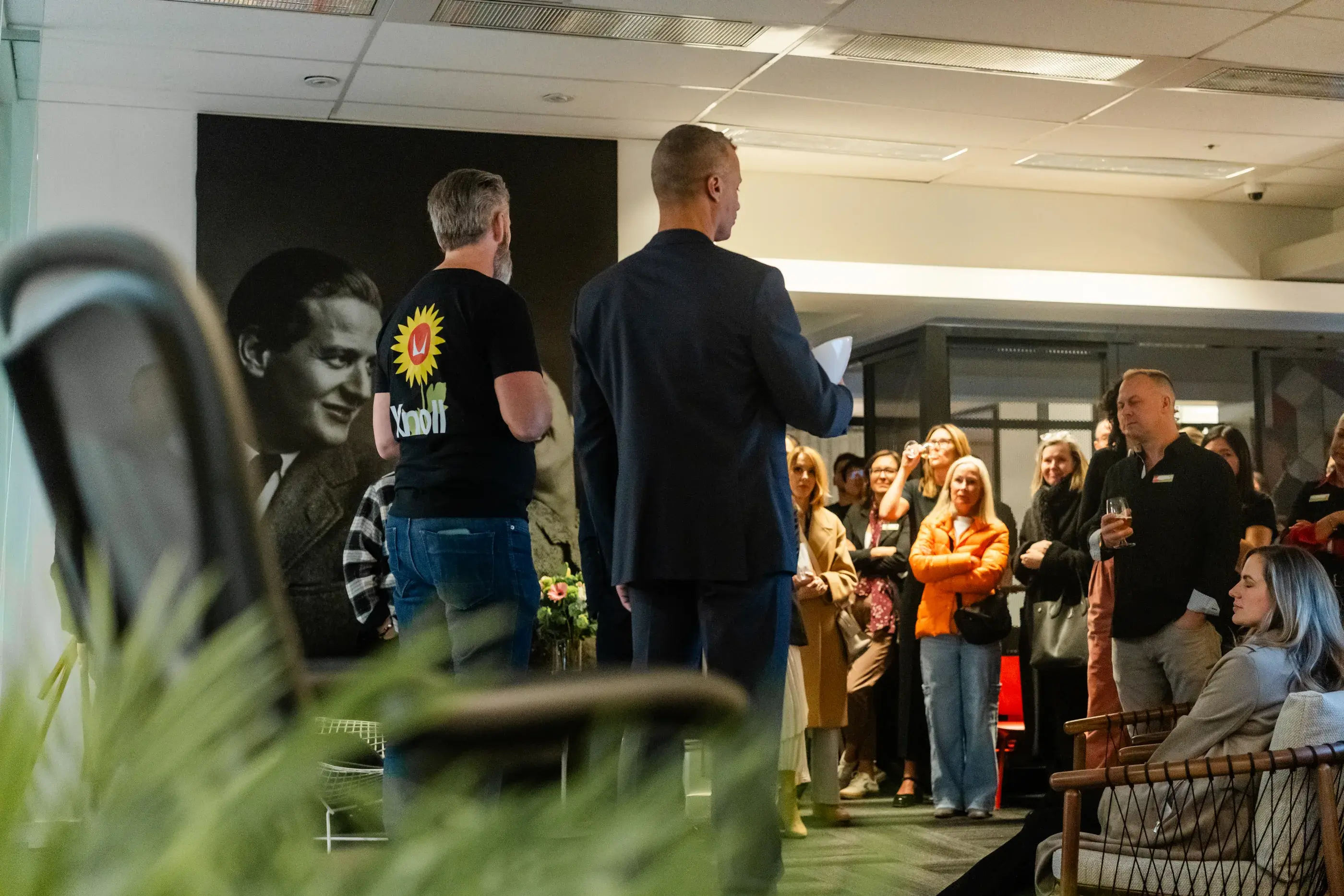 A speaker addressing guests gathered inside the Blackburn Young showroom