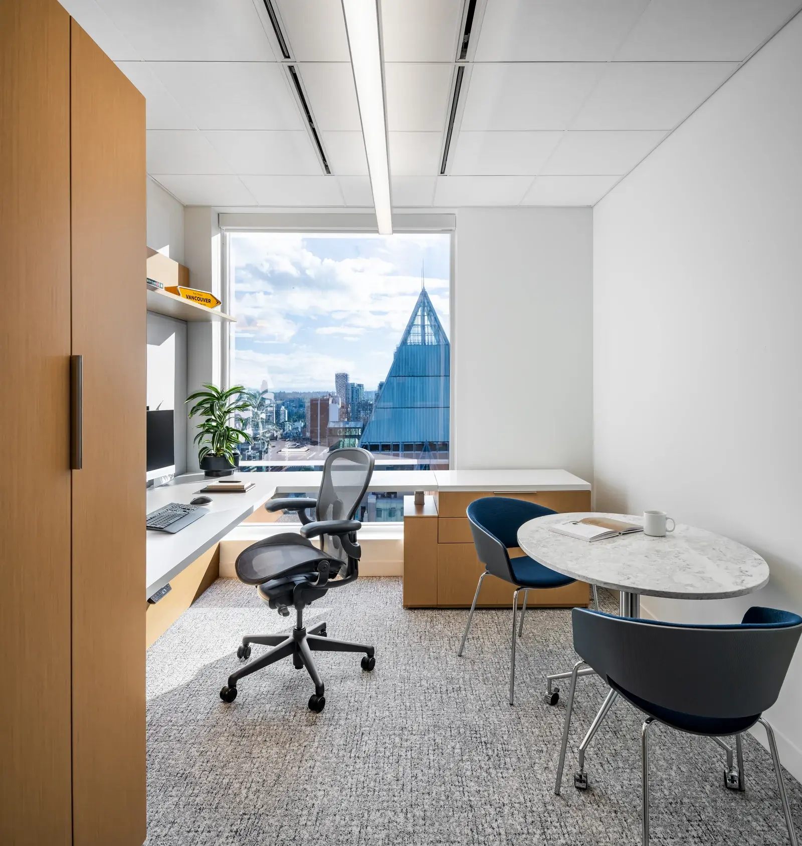 Stikeman Elliott private office with desk, meeting table and Vancouver view