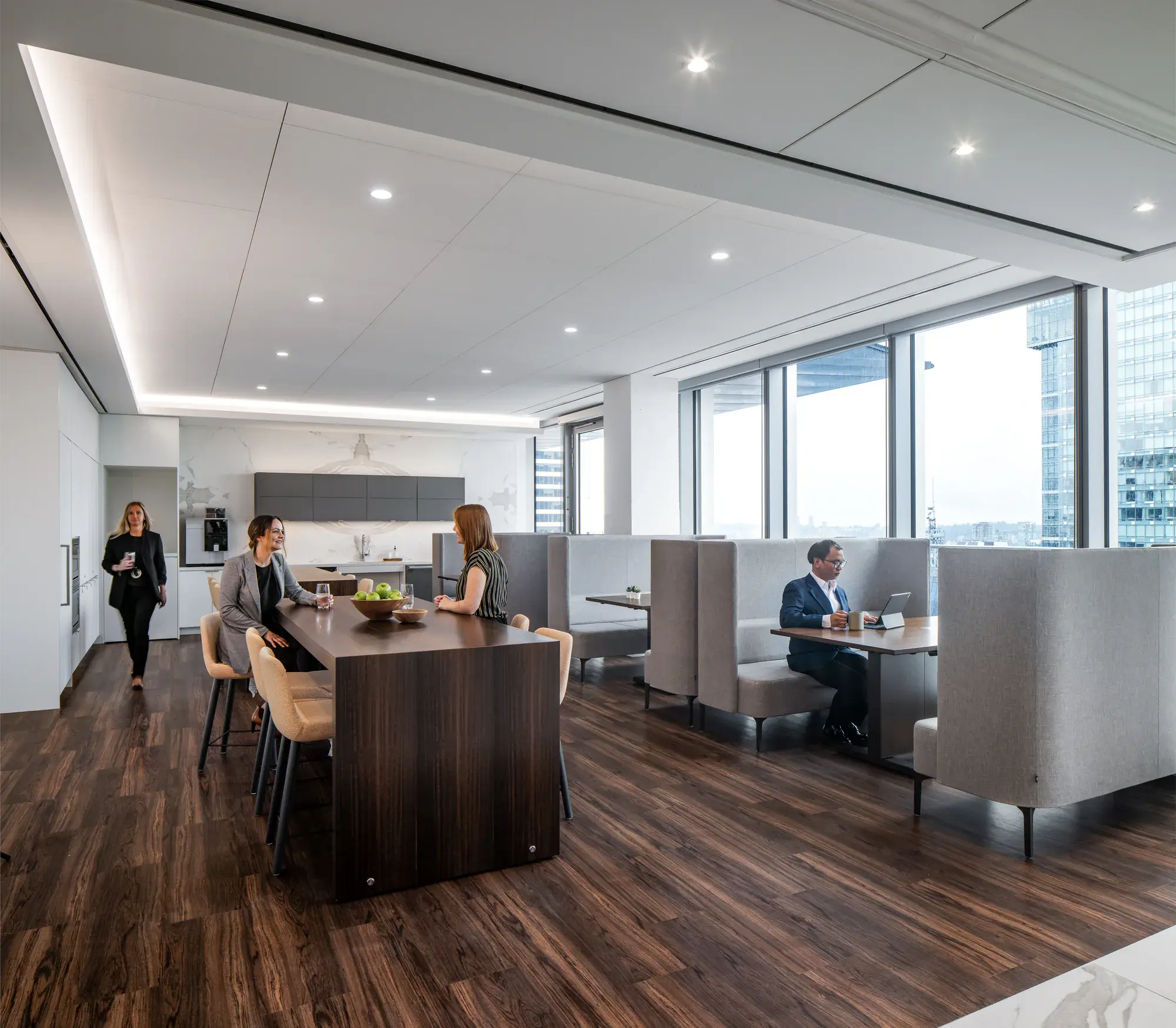 People using communal tables and booth seating in a shared workplace setting