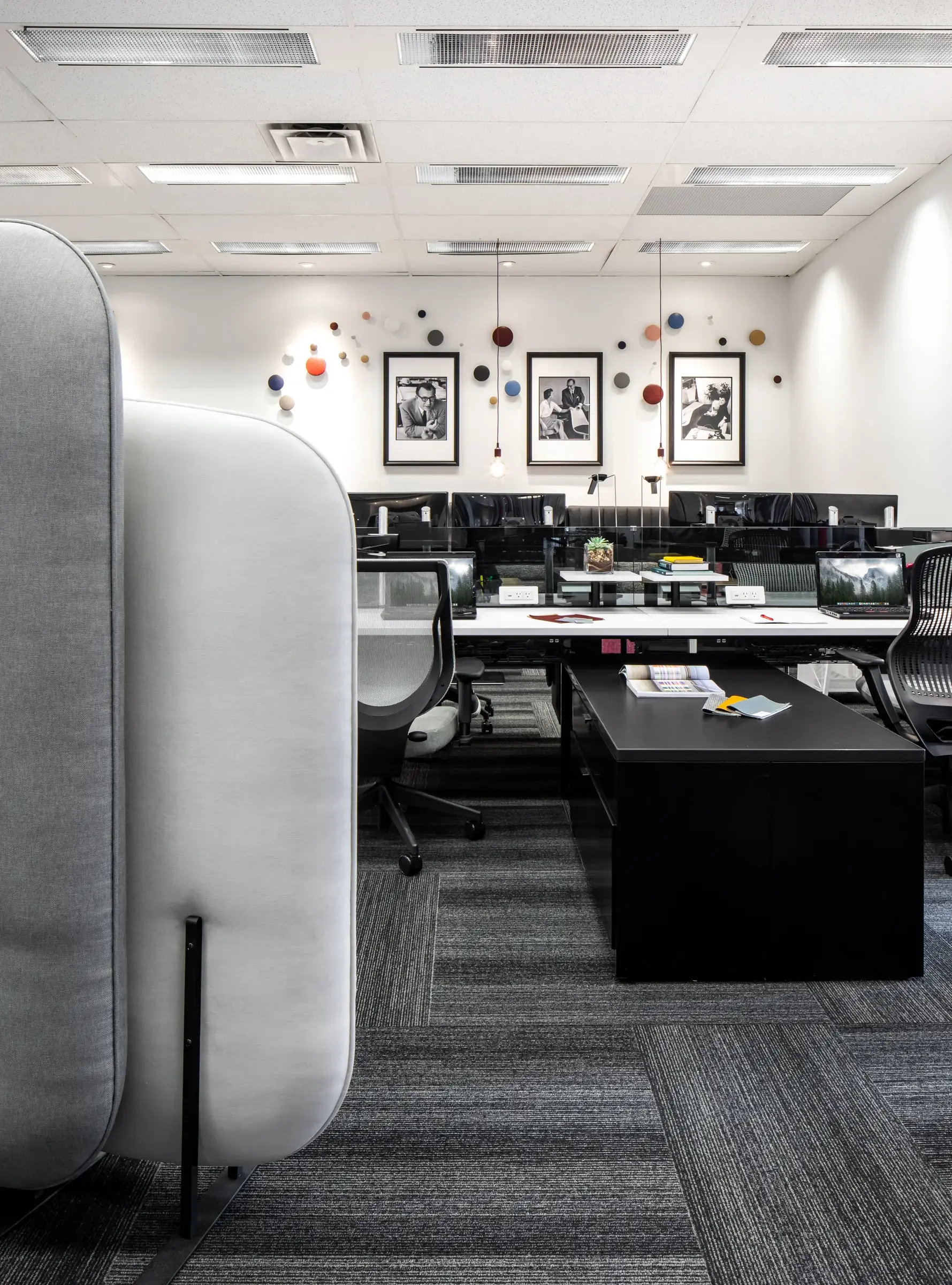 Workstations arranged behind tall upholstered privacy screens