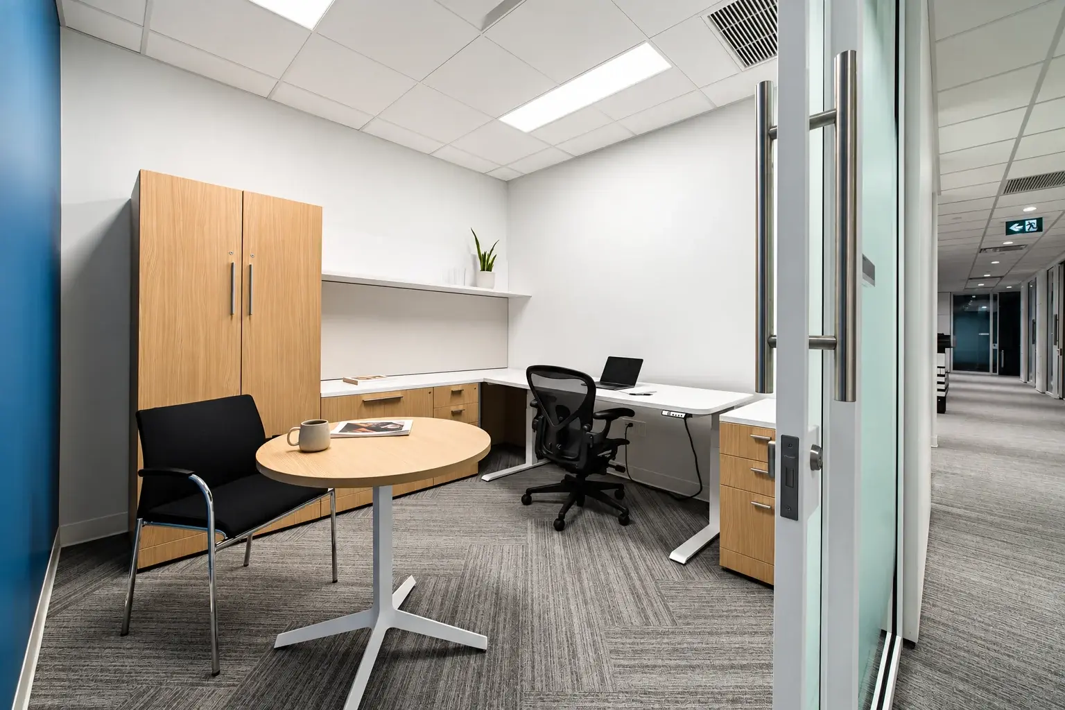 Private office with a desk and small meeting table