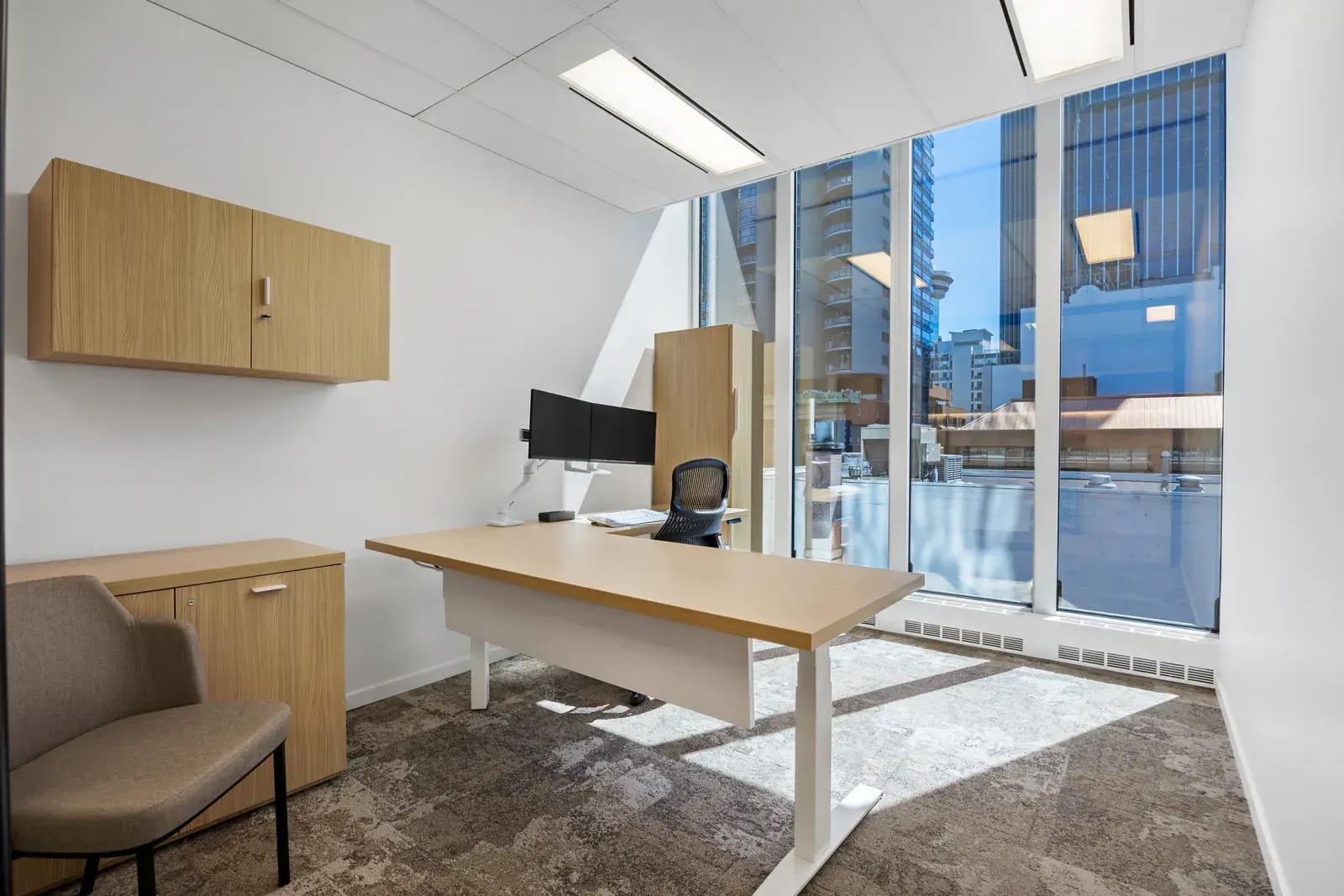 Private office with a height-adjustable desk and downtown view