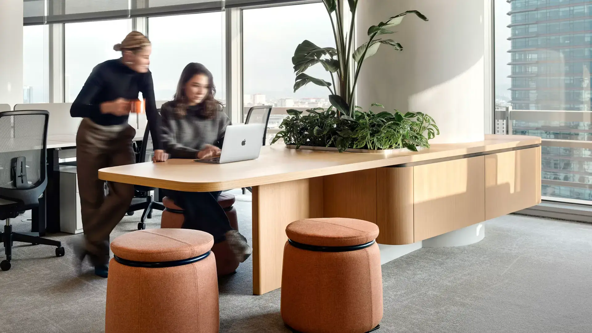 Two people collaborating at a shared workplace table